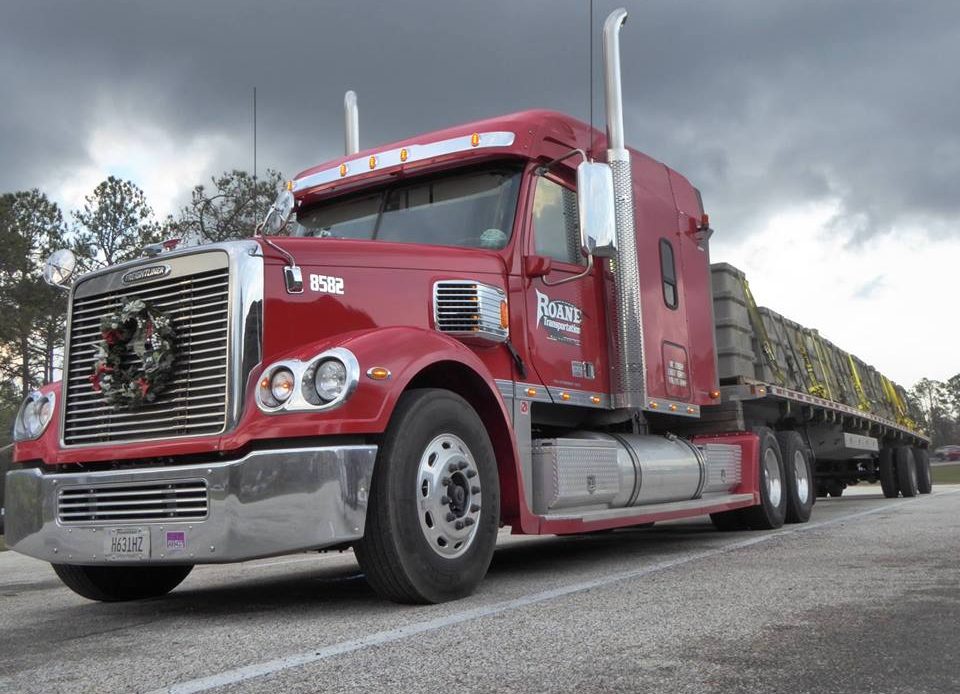 red Roane Transportation truck and flatbed trailer