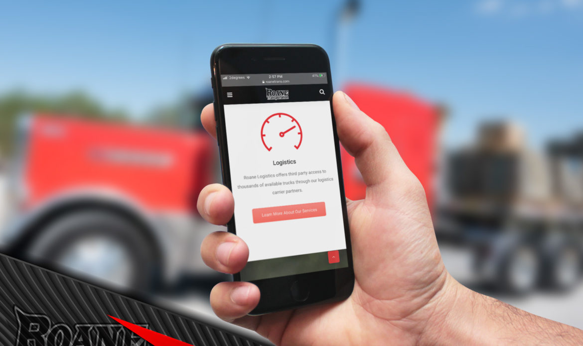 hand holding a cellphone with a trucking website displayed on the screen