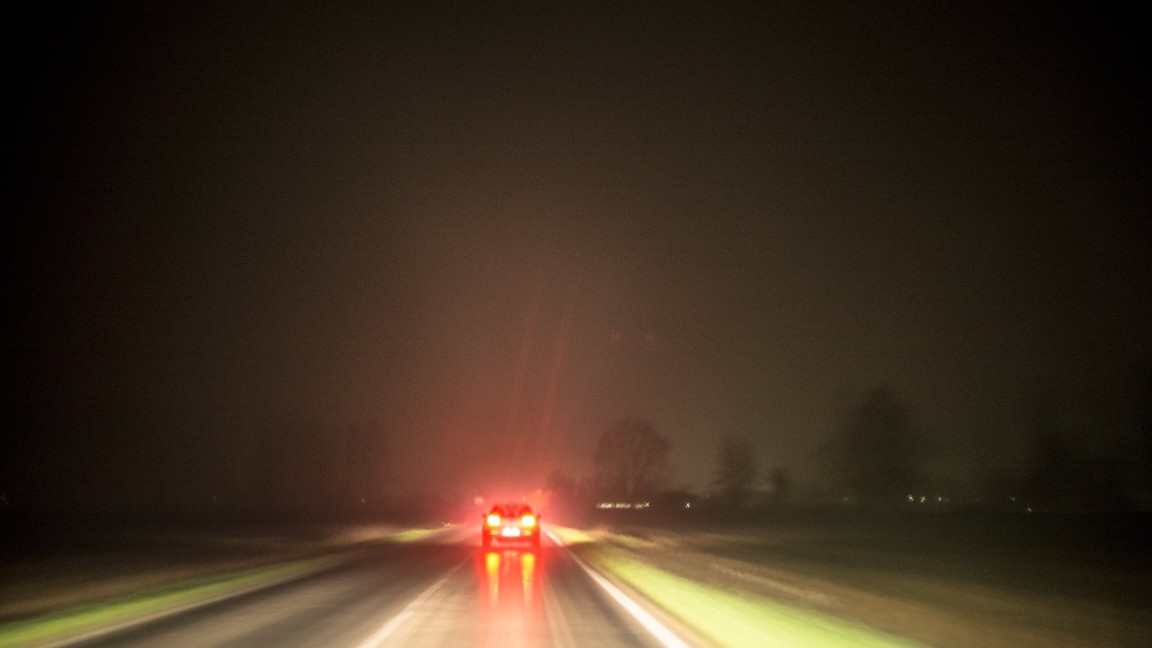 car in the distance with its brakes on followed by a semi truck that needs to stop appropriately