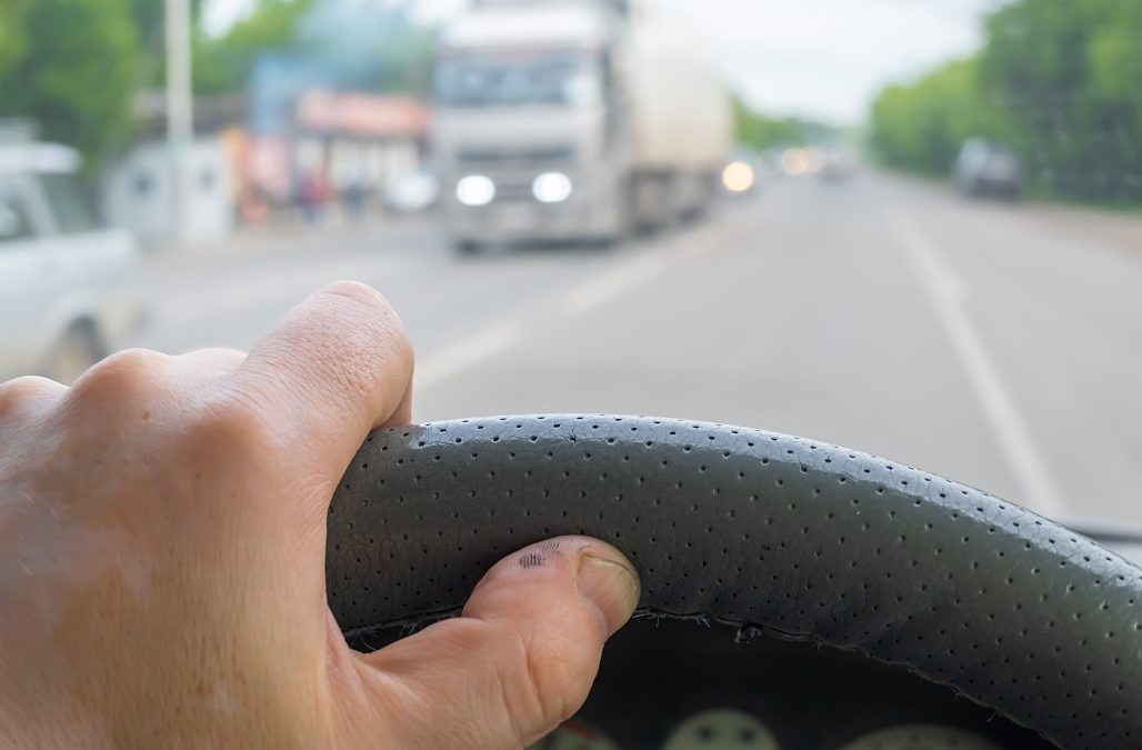 hand on the wheel of a semi truck